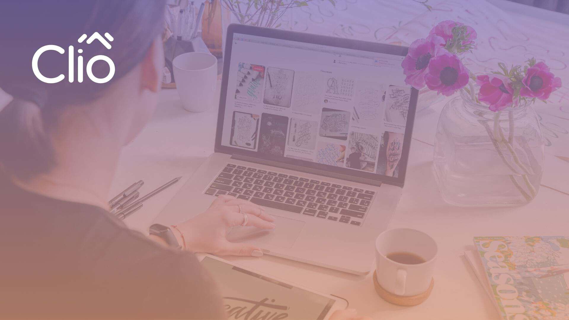 A person sits at a desk with a laptop displaying sketches, a tablet, coffee, a magazine, and flowers. The word "Clio" appears in the top left corner, highlighting how you can increase your website conversion rate using images. - Clio Websites | Top Canadian Web Design Company