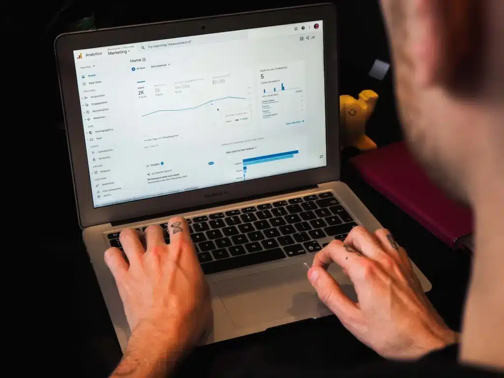 A person typing on a laptop displaying Google Analytics data, including graphs and charts showing website performance metrics and insights from SEO plugins for WordPress. - Clio Websites | Top Canadian Web Design Company