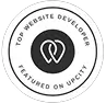 A circular badge with a black and white design features an abstract logo of two interlocking shapes. The text around reads "Clio Websites Top Developer Featured on UpCity. - Clio Websites | Top Canadian Web Design Company