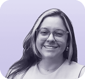 A woman with long hair and glasses smiles at the camera. She is wearing a light top and a necklace, with a soft purple background—a look often featured on about Clio websites. - Clio Websites | Top Canadian Web Design Company