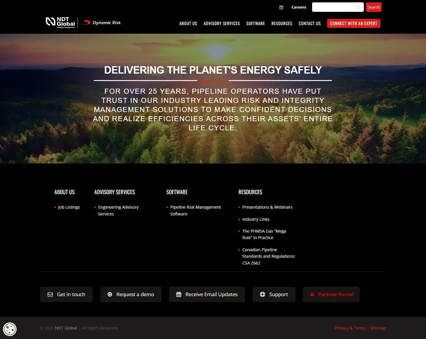 Website homepage for NDT Global with a sunset background, white and yellow text highlighting pipeline safety, navigation menus, company logo, and several call-to-action buttons at the bottom. - Clio Websites | Top Canadian Web Design Company